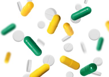 Many different pills flying on white background