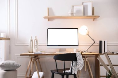 Evde rahat bir iş yeri. Odadaki boş beyaz ekranlı bilgisayar monitörü