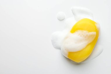 Beyaz arka planda köpük olan sabun çubuğu, üst manzara. Metin için boşluk