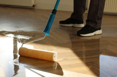Parke cilalayan adam kapalı mekanda vernikle, yakın plan