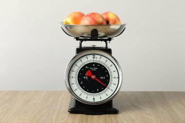 Retro mechanical kitchen scale with apples on wooden table