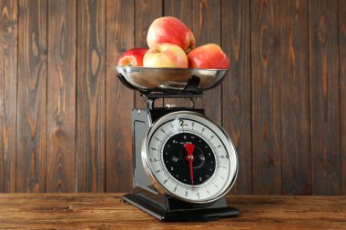 Retro mechanical kitchen scale with apples on wooden table