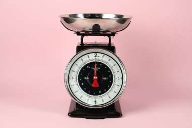One mechanical kitchen scale on pink background