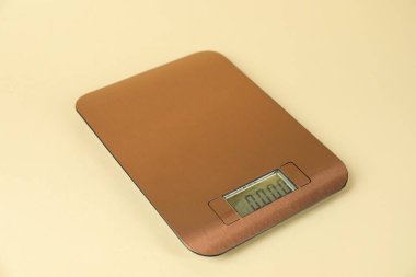 One electronic kitchen scale on beige background, closeup