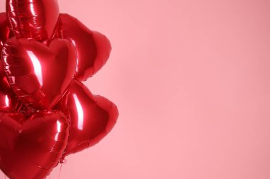 Pembe arka planda bir sürü kırmızı kalp şeklinde balon, mesaj için boşluk. Sevgililer Günün kutlu olsun.