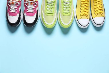 Spor ayakkabılar. Açık mavi arka planda, düz zeminde farklı spor ayakkabılar. Metin için boşluk