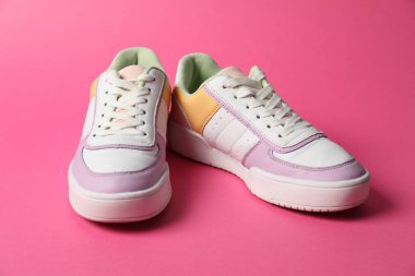 Pembe arka planda şık ayakkabılar. Spor ayakkabılar.
