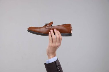 Gri arka planda şık ayakkabılı adam, yakın plan.