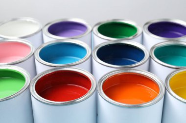 Cans of different paints on light background, closeup
