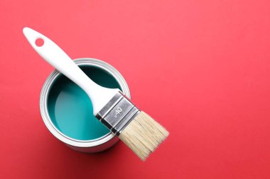 Kırmızı arka planda parlak boya ve fırça kutusu, üst manzara. Metin için boşluk