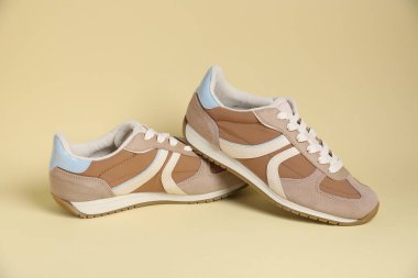 Pair of stylish sneakers on beige background. Casual shoes