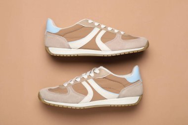 Pair of stylish sneakers on beige background, flat lay. Casual shoes