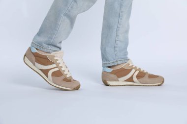 Beyaz arka planda şık ayakkabılar giyen kadın, yakın plan.