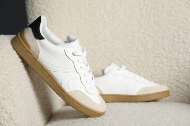 Hafif koltukta şık bir çift spor ayakkabı.