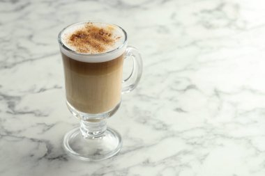 Beyaz mermer masada cam bardakta latte macchiato, yakın plan. Metin için boşluk