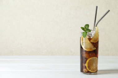 Limon dilimli taze buzlu kola ve beyaz ahşap masada nane şekeri. Metin için boşluk