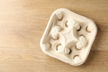 Empty cardboard cup holder on wooden table, top view. Space for text