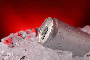 Koyu kırmızı arka planda buz kalıplarındaki içecekler tazeleniyor. Yakın plan.