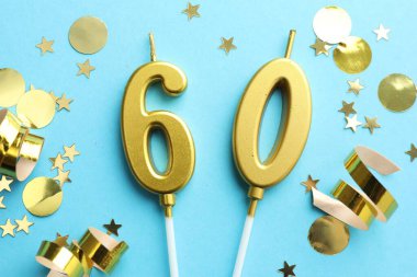 60. yaş günü. Açık mavi arkaplandaki mumlar ve konfetiler düzdü.