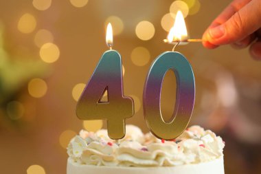 40. yaş günü. Işıklandırma numarası pastadaki mumları bulanık ışıklara karşı şekillendiriyor. Bokeh etkisi