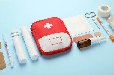 First aid kit. Different medical supplies on light blue background