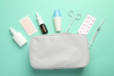 First aid kit. Different medical supplies on turquoise background, flat lay