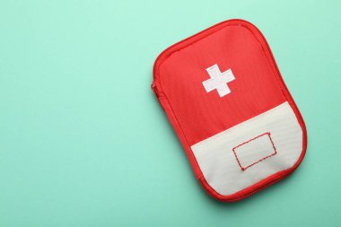First aid kit on turquoise background, top view. Space for text
