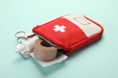 First aid kit. Different medical supplies on light blue background, closeup