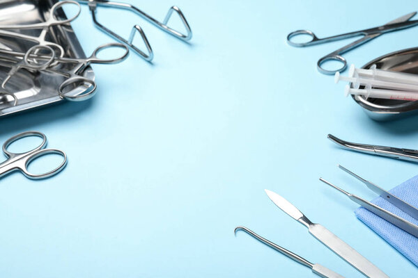 Different surgical tools on light blue background, closeup. Space for text