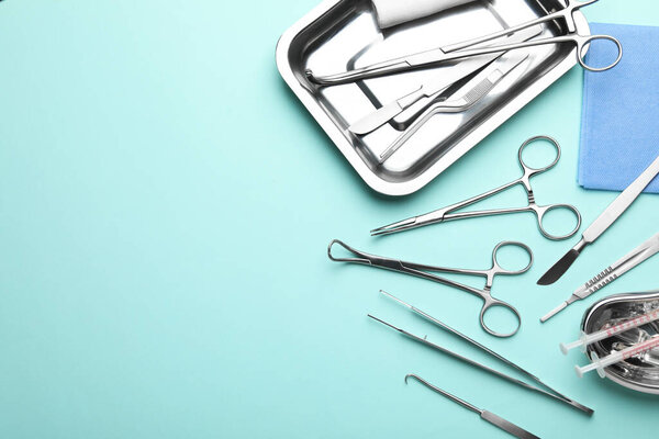 Различные хирургические инструменты на бирюзовом фоне, плоский узор. Пространство для текста