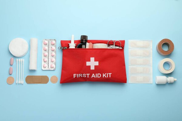 First aid kit. Different medical supplies on light blue background, flat lay