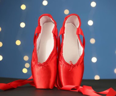 Bulanık ışıklara karşı siyah masada bir çift şık sivri ayakkabı.