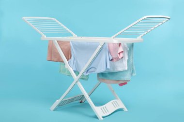 Açık mavi arka planda temiz çamaşırlı kuru askı.