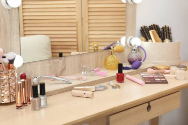 Makyaj odası. İçerideki ahşap tuvalet masasında ve aynada farklı güzellik ürünleri.