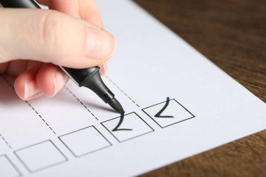 Masada kağıt kutusunu işaretleyen kadın, yakın plan.