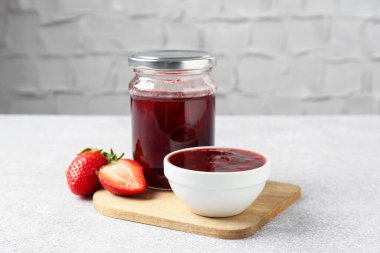 Delicious strawberry sauce and fresh berries on light table