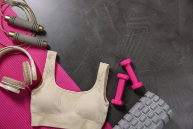 Farklı jimnastik aletleri ve kulaklıklar koyu gri desenli arka plan, düz yatak. Metin için boşluk