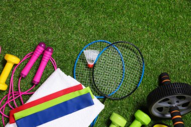 Yapay yeşil çimlerde farklı spor aletleri, düz yatış. Metin için boşluk