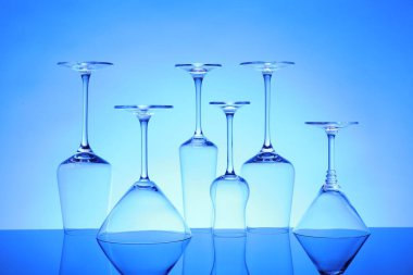 Ayna yüzeyinde birçok boş bardak mavi arkaplana karşı