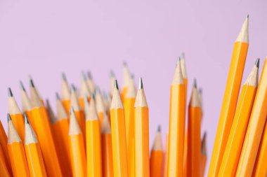 Many graphite pencils on pink background, closeup