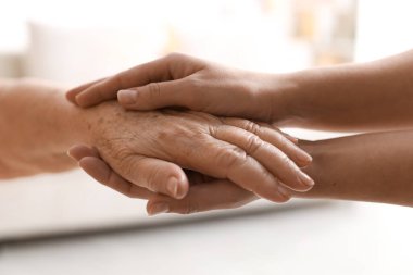 Son sınıf öğrencisine arka planda destek veren bakıcı, yakın plan. Yaşlı bakımı