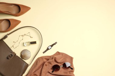 Şık kadın kıyafetleri ve bej arka planda farklı aksesuarlar. Metin için boşluk