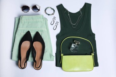 Şık kadın kıyafetleri ve beyaz arka planda farklı aksesuarlar.