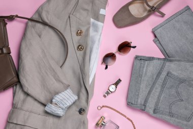 Açık pembe arka planda ceketli ve aksesuarlı şık kıyafetler.