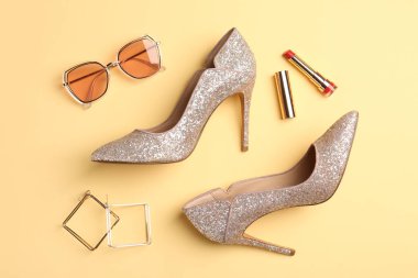 Heels and stylish accessories on beige background, flat lay