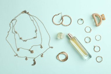 Stylish accessories and perfume on light blue background, flat lay