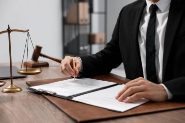 Ofisteki ahşap masada noter imzalı belge, yakın plan.