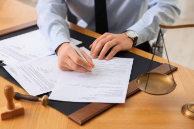 Ofisteki ahşap masada noter imzalı belge, yakın plan.