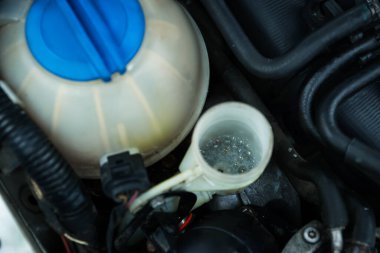Windshield washer reservoir with fluid, closeup view