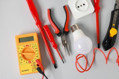 Different electrical tools on grey background, flat lay